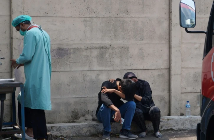 Des proches de victimes de l'incendie pleurent devant la prison de Tangerang, en Indonésie, le 8 septembre 2021