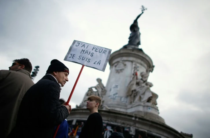 Un homme porte une pancarte Ă l'occasion du rassemblement en hommage aux victimes des attentats, le 10 janvier 2016 Ă Paris