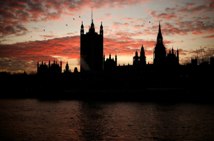 Coucher de soleil derrière le Palais de Westminster, qui abrite la Chambre des Communes où se réunit le Parlement, à Londres le 8 décembre 2020