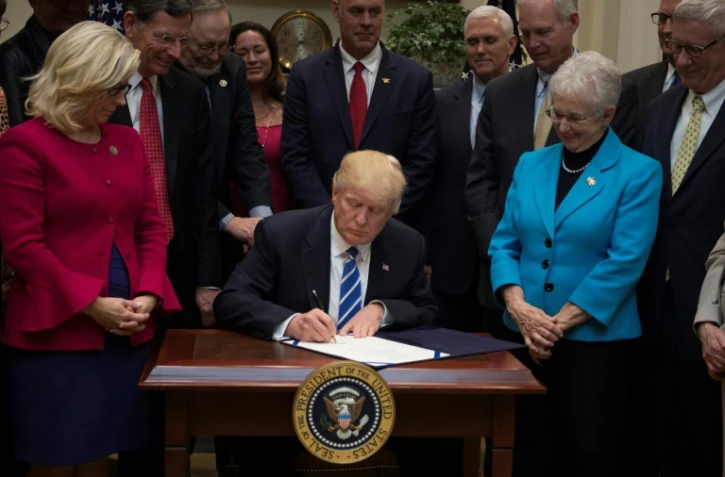 Le président américain Donald Trump signe des décrets à la Maison Blanche, le 27 mars 2017 à Washington