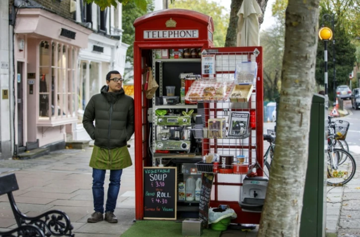 Umar Khalid debout devant le coffee shop qu'il tient depuis une ancienne cabine téléphonique à Londres, le 20 octobre 2017