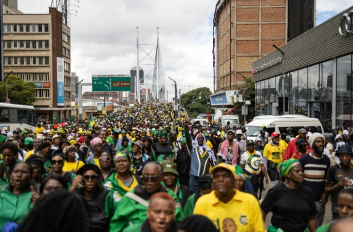 Des milliers de manifestants, appelés à défiler par l'ANC, traversent l'emblématique pont Nelson Mandela de Johannesburg le 21 mars 2026.