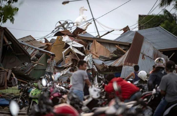 Des indonésiens récupèrent des affaires dans les décombres de leurs maisons après un séisme et un tsunami à Palu, dans l'île des Célèbes, le 29 septembre 2018