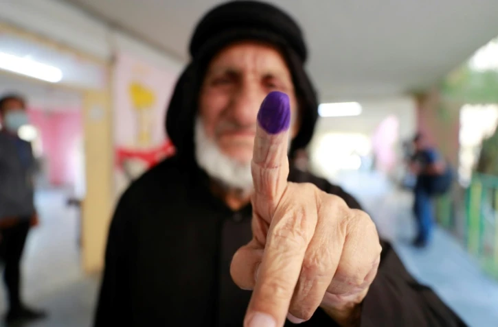Une Irakienne montre son index teinté d'encre après avoir voté aux législatives à Bagdad, le 10 octobre 2021 