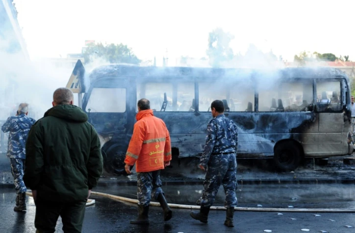 Photo transmise par l'agence syrienne SANA montrant un bus calciné après l'explosion d'une bombe à Damas, le 20 octobre 2021