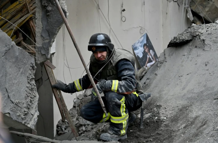 Un sauveteur sur le site d'une attaque de missiles russes Ă Kiev, le 25 mars 2024 en Ukraine