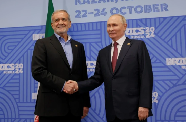 Le président russe Vladimir Poutine (d) et son homologue iranien Massoud Pezeshkian, lors d'une rencontre en marge du sommet des Brics, le 23 octobre 2024 à Kazan