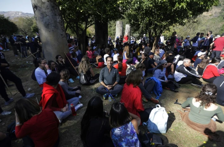 Des Libanais font une pause près du pont romain lors d'une marche de 20 km dans la vallée de Bisri, au sud-ouest de Beyrouth, le 22 novembre 2019, pour protester contre la construction d'un barrage dans la région