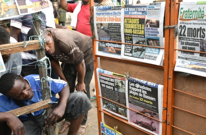 Les Ivoiriens consultent les Unes des quotidiens, le 14 mars 2016 au lendemain d'une attaque jihadiste qui a fait 16 morts dans la station balnéaire de Grand-Bassam