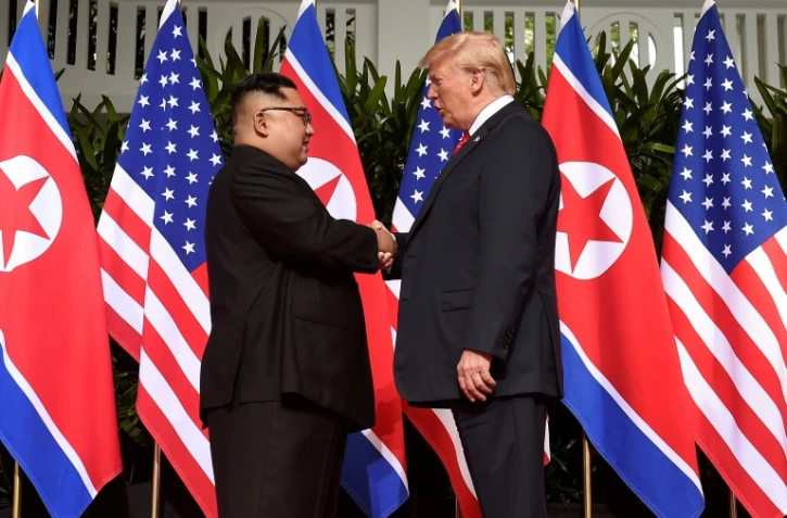 Le leader nord-coréen Kim Jong Un (g) serre la main au président américain Donald Trump (d) avant le début du sommet historique à l'hôtel Capella, le 12 juin 2018 à Singapour