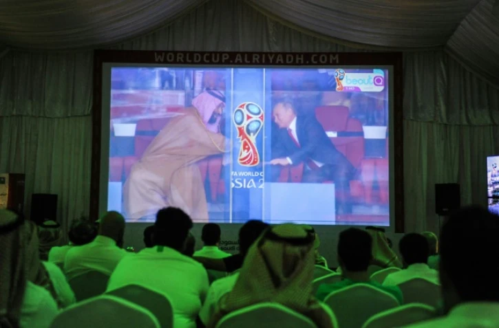 Les Saoudiens assistent, depuis Riyad, à la poignée de mains entre le prince héritier Mohammed ben Salmane et le président Vladimir Poutine à l'ouverture du Mondial à Moscou, le 14 juin 2018