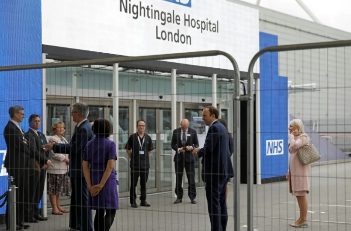 Le ministre britannique de la Santé Matt Hancock (2e en partant de la droite) à l'ouverture de 
l'hôpital de Nightingale, installé sur le site d'un centre de conférences à Londres le 3 avril 2020.