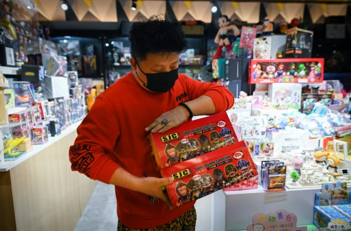 Un vendeur d'un magasin de jouets montre une "blind box" contenant des figurines à l'effigie de mangas, le 7 avril 2021 à Pékin, en Chine