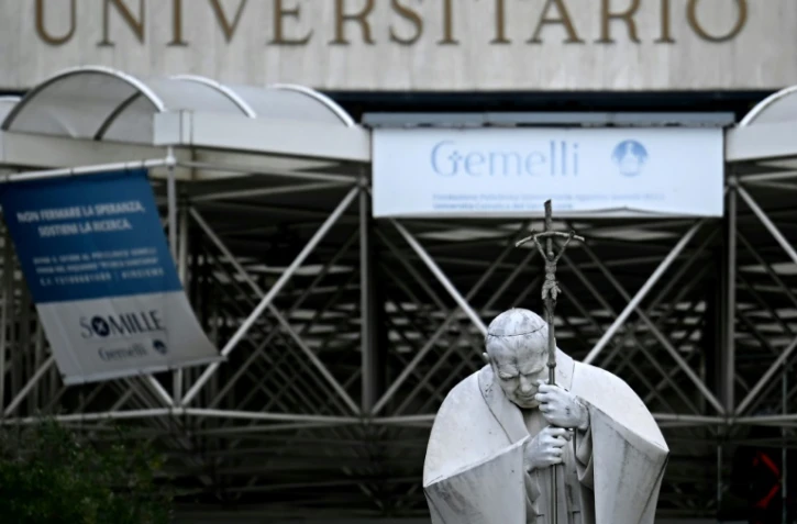 Une statue du pape Jean-Paul II devant l'hôpital Gemelli où le pape François est hospitalisé pour une bronchite, le 17 février 2025 à Rome  