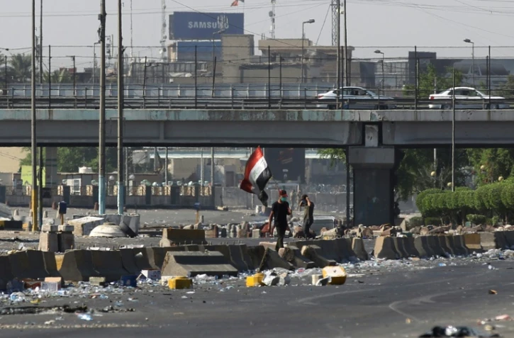 Un drapeau irakien est brandi lors d'une manifestation contre le pouvoir Ă Bagdad, le 4 octobre 2019