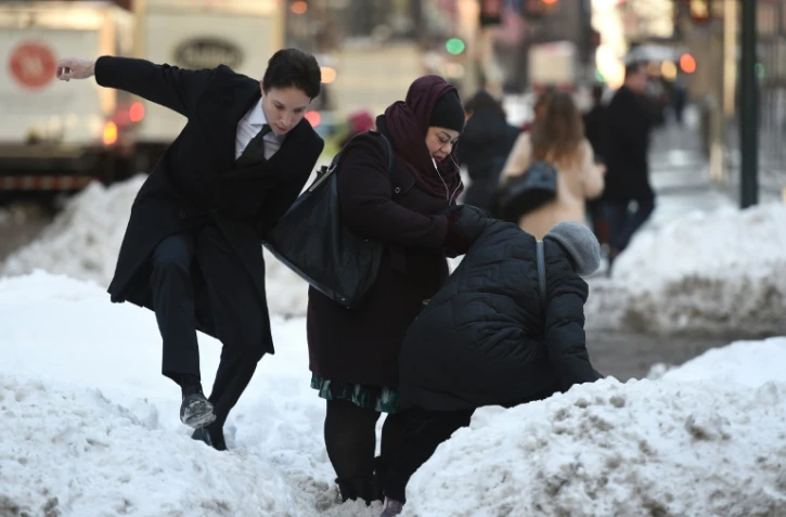 Difficultés pour les passants à se frayer un chemin sur Park avenue à New York, le 25 janvier 2016 après d'importantes chutes de neige