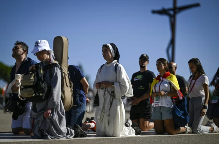 Des pélerins agenouillés au sanctuaire de Fatima, au Portugal, le 4 août 2023, à la veille d'un déplacement du pape François