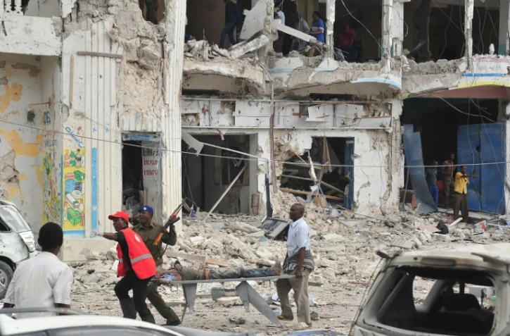Des habitants transportent un blessé après une double explosion près d'un hôtel de Mogadiscio, le 25 janvier 2017 en Somalie