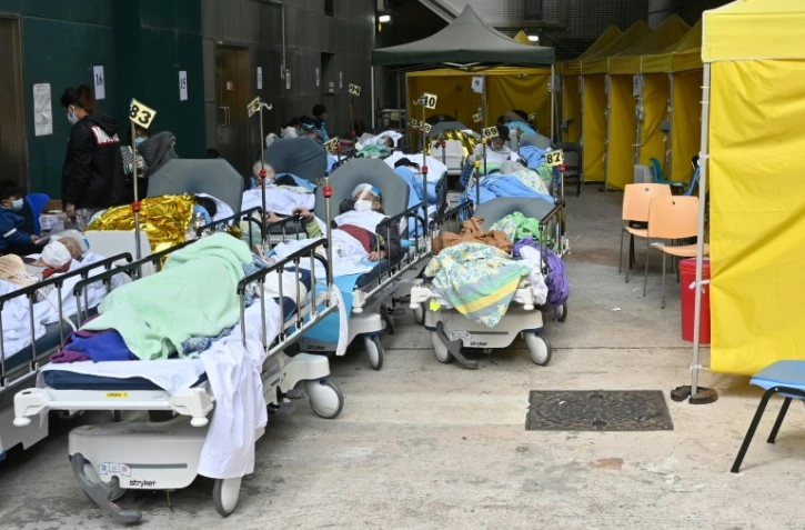 Des patients attendent sur des lits devant le centre médical Caritas, le 15 février 2022 à Hong Kong où le nombre de contaminations au Covid-19 a grimpé en flèche