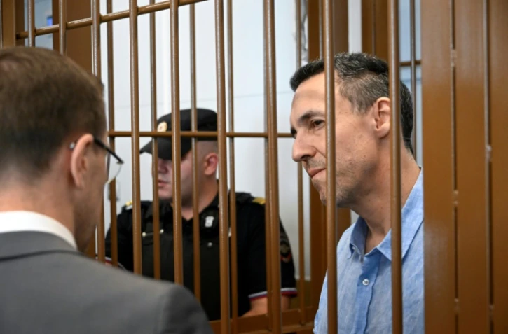 Le Français Laurent Vinatier, accusé de ne pas s'être enregistré en tant qu'"agent de l'étranger", écoute son avocat depuis la cage des accusés lors d'une audience au tribunal du district de Zamoskvoretsky à Moscou, le 3 septembre 2024