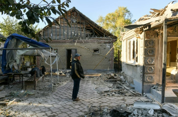 Un habitant dans la cour dde sa maison endommagée par une frappe de missile, le 15 octobre 2023 à Donetsk