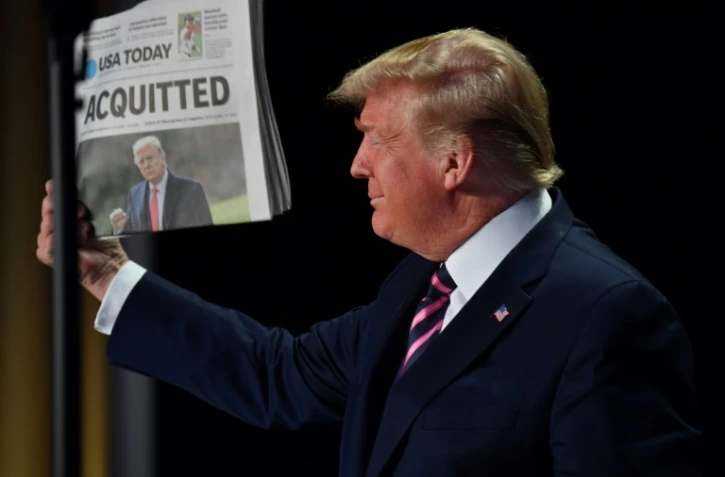 Le président américain Donald Trump brandit un exemplaire du quotidien USA Today au lendemain de son acquittement par le Sénat 