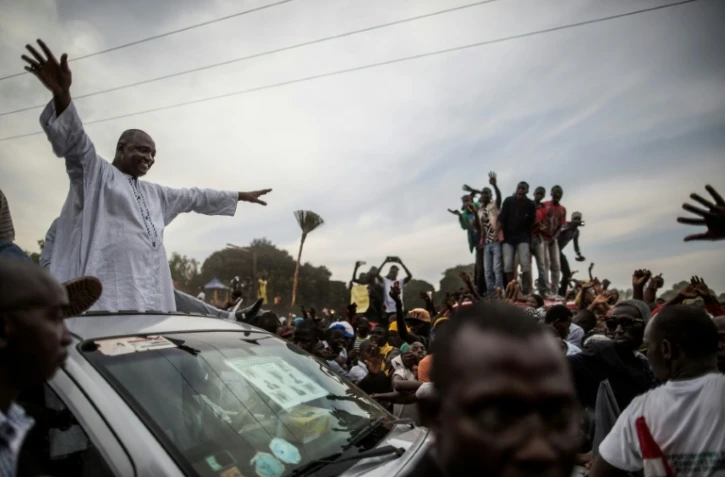 Adama Barrow, porte-drapeau de la coalition des sept partis politiques d'opposition en Gambie, salue les partisans du toit de sa voiture lors d'un rassemblement dans la zone tampon de Talinding le 29 novembre 2016