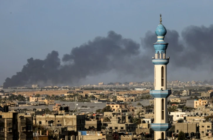 Une photo prise de Rafah montrant un nuage de fumée s'élevant le 22 janvier 2024 au dessus de Khan Younès dans le sud de Gaza après des combats entre l'armée israélienne et le groupe islamiste palestinien du Hamas