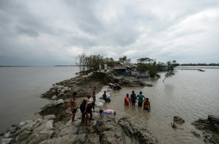 Des habitants tentent de consolider une digue après le passage du cyclone Amphan, le 21 mai 2020 à Burigoalini, au Bangladesh