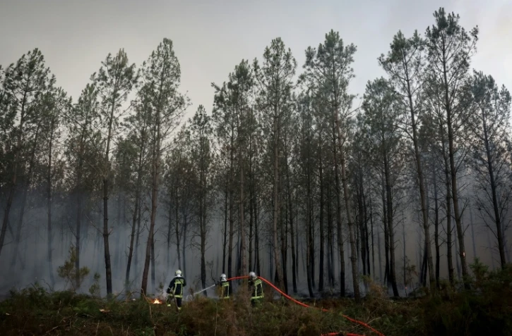 Des pompiers luttent contre un incendie de forêt à Saint-Jean-d'Illac, à environ 30 km de Bordeaux, alors qu'un feu de forêt ravage la forêt au nord du bassin d'Arcachon en Gironde