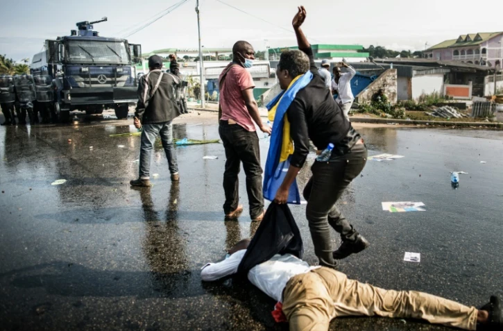 Un partisan de l'opposant gabonais Jean Ping évacue un blessé lors d'une manifestation dénonçant la réélection d'Ali Bongo, le 31 août 2016 à Libreville