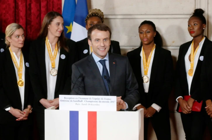 Le président Emmanuel Macron (c) rend hommage aux handballeuses françaises championnes du monde lors d'une allocution au Palais de l'Elysée, le 18 décembre 2017