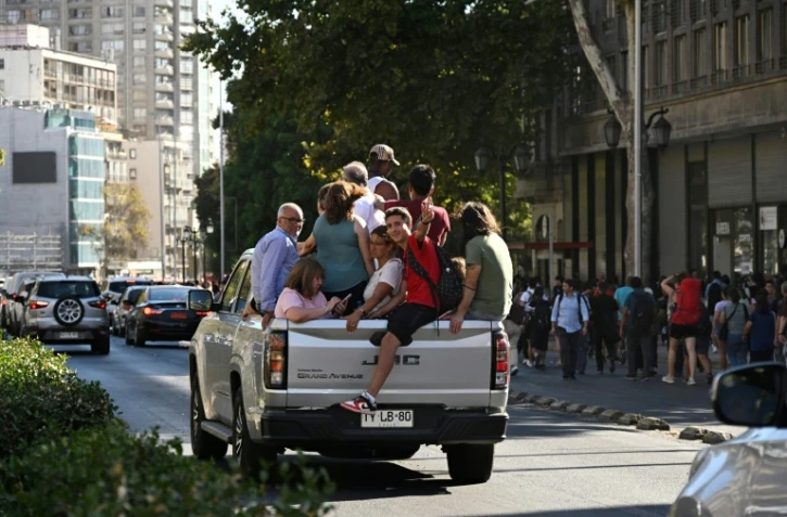 Des personnes entassées dans un pick-up lors d'une passe d'électricité massive, le 25 février 2025 à Santiago