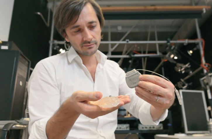 Le scientifique Grégoire Courtine manipule les implants qui ont permis à des singes de recouvrir le contrôle de leurs membres inférieurs paralysés, à l'Ecole polytechnique de Lausanne, le 27 octobre 2016
