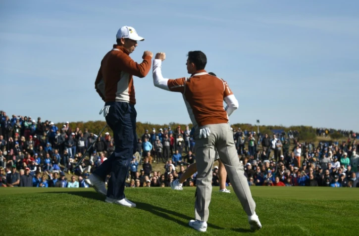 Rory McIlroy et Sergio Garcia (casquette) se congratulent après un bon point face aux Américains pour la 2e journée de la Ryder Cup, à Saint-Quentin, près de Paris, le 29 septembre 2018