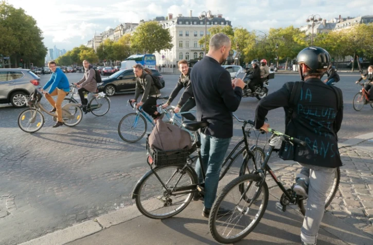 Des cyclistes circulent près de l'Arc de Triomphe le 22 septembre 2015 à l'appel du mouvement "Velorution" en prélude à la journée sans voiture du 27 septembre 2015 à Paris
