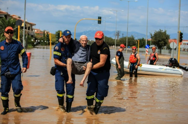 Des pompiers évacuent un homme âgé d'une zone inondée à Larissa, le 9 septembre 2023 dans le centre de la Grèce