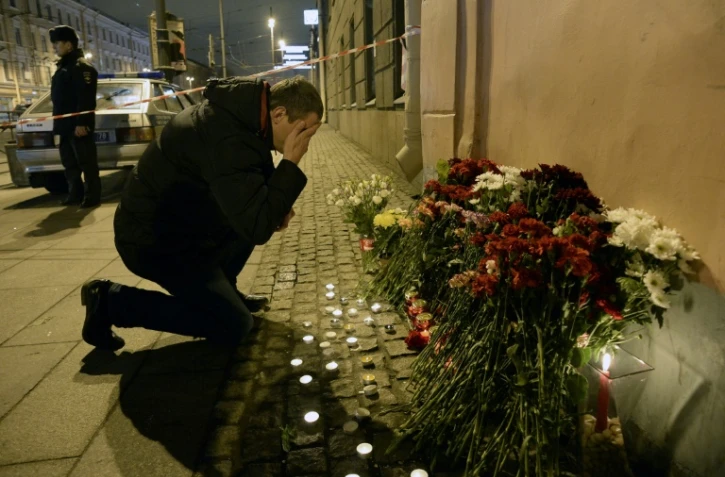 Un homme se recueille après avoir déposé des fleurs en mémoire aux victimes d'un attentat dans le métro, le 3 avril 2017 à Saint-Pétersbourg