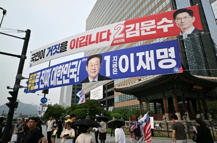 Des banderoles des candidats à la présidentielle Kim Moon-soo (en rouge) et Lee Jae-myung dans une rue de Séoul, le 31 mai 2025, avant l'élection du 3 juin