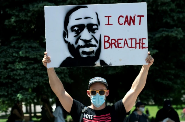 Un manifestant porte une pancarte Ă l'effigie de George Floyd, le 30 mai 2020 Ă Denver, dans le Colorado, avec ses derniers mots: "Je ne peux pas respirer"