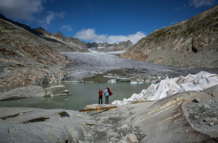 Des touristes devant le glacier du Rhône près de Gletsch, dans les Alpes suisses, le 12 septembre 2025