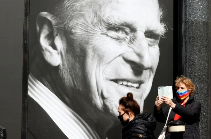 Deux passantes devant le portrait de feu le prince Philip, Ă Windsor (Royaume-Uni), le 16 avril 2021
