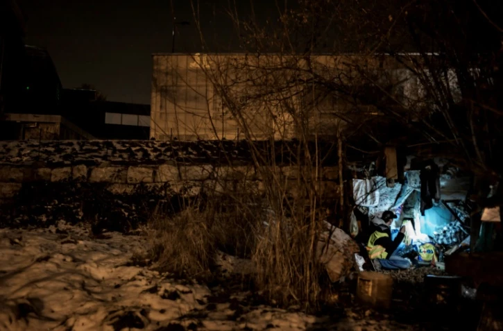 Un membre de l'Association Savoyarde d'Accueil des Secours et d'Orientation (SASSON) aide des familles de sans abri le 16 janvier 2017 dans une forêt de Chambéry