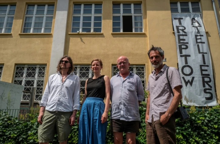 Les artistes allemands Sebastian Koerbs et Lydia Paasche (g) aux côtés de leur collègue irlandais Lorcan O'Byrne et du photographe italien Michele Caliari (d), devant les Treptow Ateliers à Berlin, le 20 juin 2019