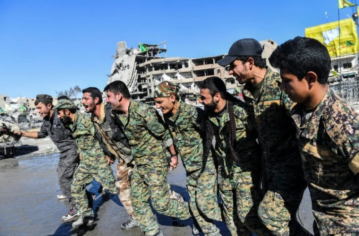 Membres des Forces démocratiques syriennes (FDS) célébrant le 18 octobre 2017 à Raqa la prise de cette ville