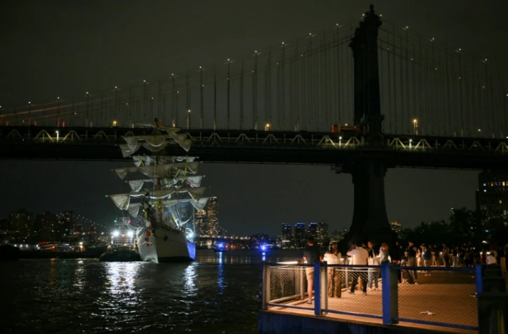Des personnes regardent un navire-école de la marine mexicaine après qu'il a heurté le pont de Brooklyn à New York, le 17 mai 2025