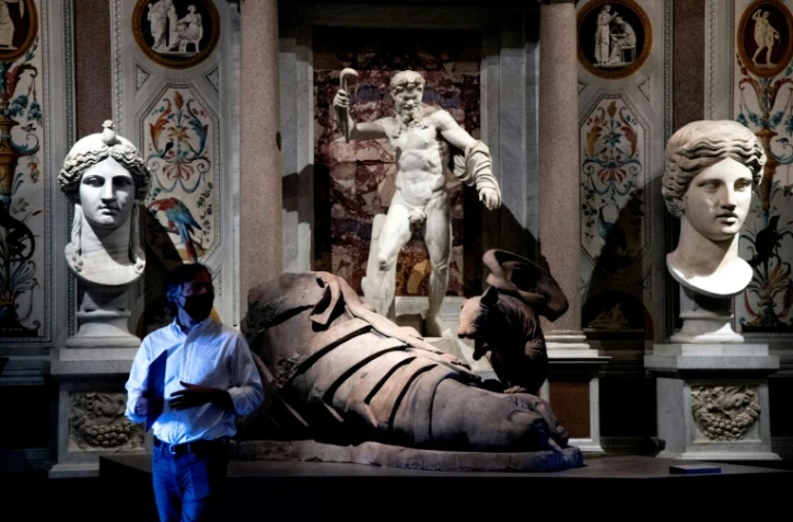 A very modern lab rat perches on Hirst's massive sandalled foot sculpture