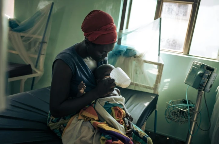 Agnès, une déplacée de 33 ans, nourrit sa fille avec du lait thrérapeutique à l'hôpital de Rutshuru, dans l'est de la Réplique démocratique du Congo (RDC), le 22 juillet 2022
