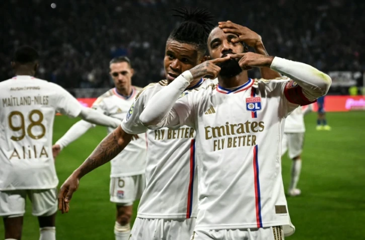 L'avant-centre et capitaine lyonnais Alexandre Lacazette (d) buteur contre l'OM et félicité par Gift Orban (c), le 4 février 2024 à Décines-Charpieu 