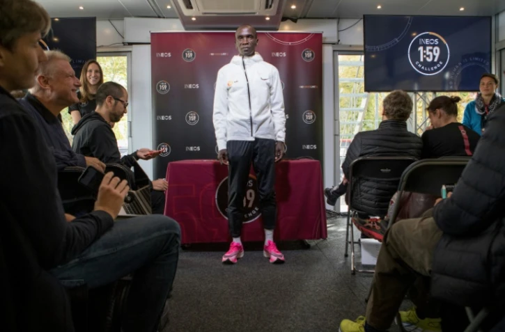 Le marathonien kényan Eliud Kipchoge (c) pose pour les photographes, le 10 octobre 2019 à Vienne